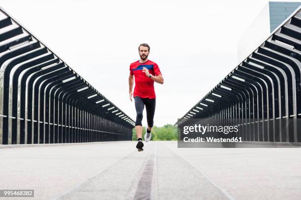 man running on a bridge - naderen stockfoto's en -beelden