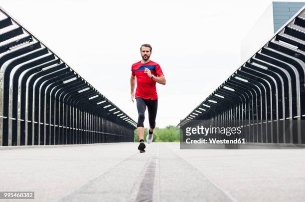 man running on a bridge - forward athlete stock pictures, royalty-free photos & images