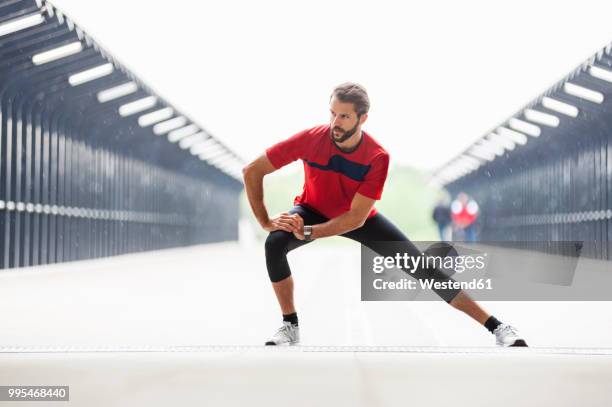 man stetching on a bridge - runner warming up stock pictures, royalty-free photos & images