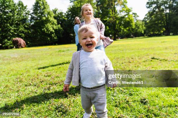 happy boy with family in a park - einjährig stock-fotos und bilder