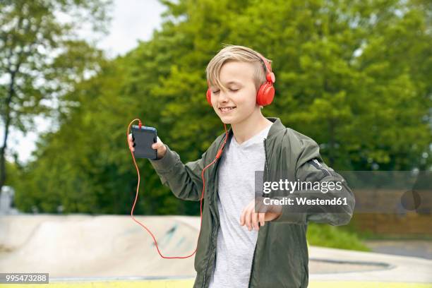 boy with headphone dancing while listing to music on smartphone - boy headphones imagens e fotografias de stock