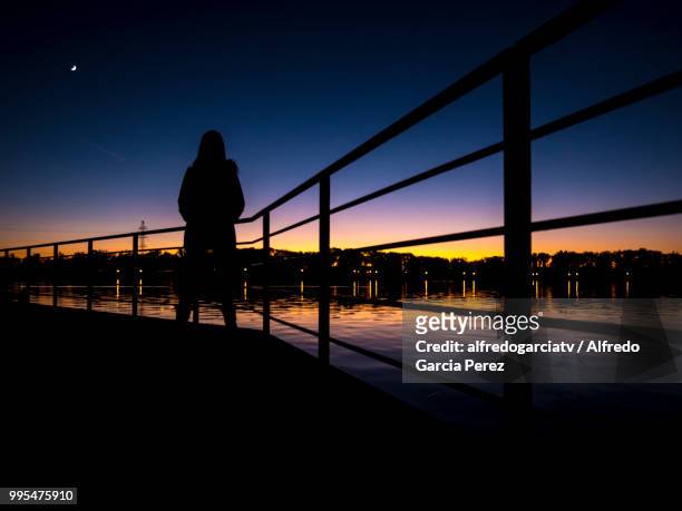 mujer a contraluz / puesta de sol en lago - puesta de sol - fotografias e filmes do acervo