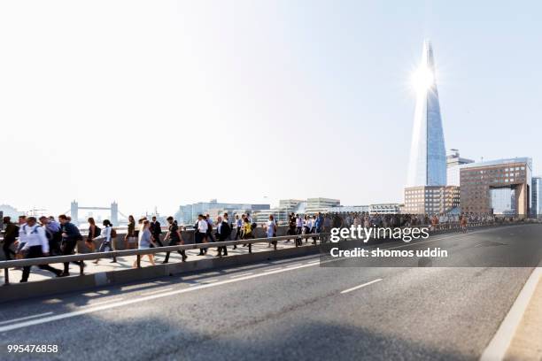 morning rush on london bridge with view of southwark skyline behind - london bridge england fotografías e imágenes de stock