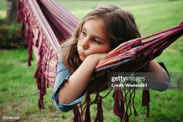 portrait of sad girl lying in hammock - aburrimiento fotografías e imágenes de stock