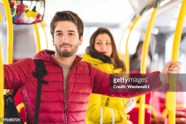 uk, london, portrait of young man travelling by bus - ダウンジャケット ストックフォトと画像