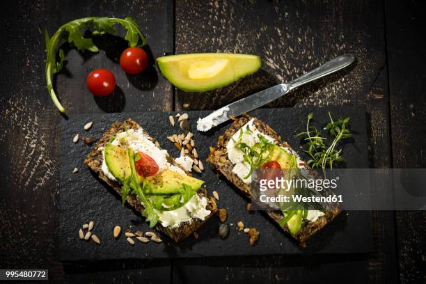 onion bread with cream cheese, parma ham, avocado, rucola, thyme and tomato - frischkäse stock-fotos und bilder