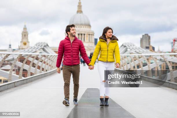 uk, london, young couple walking hand in hand on bridge in front of st pauls cathedral - st pauls cathedral london - fotografias e filmes do acervo