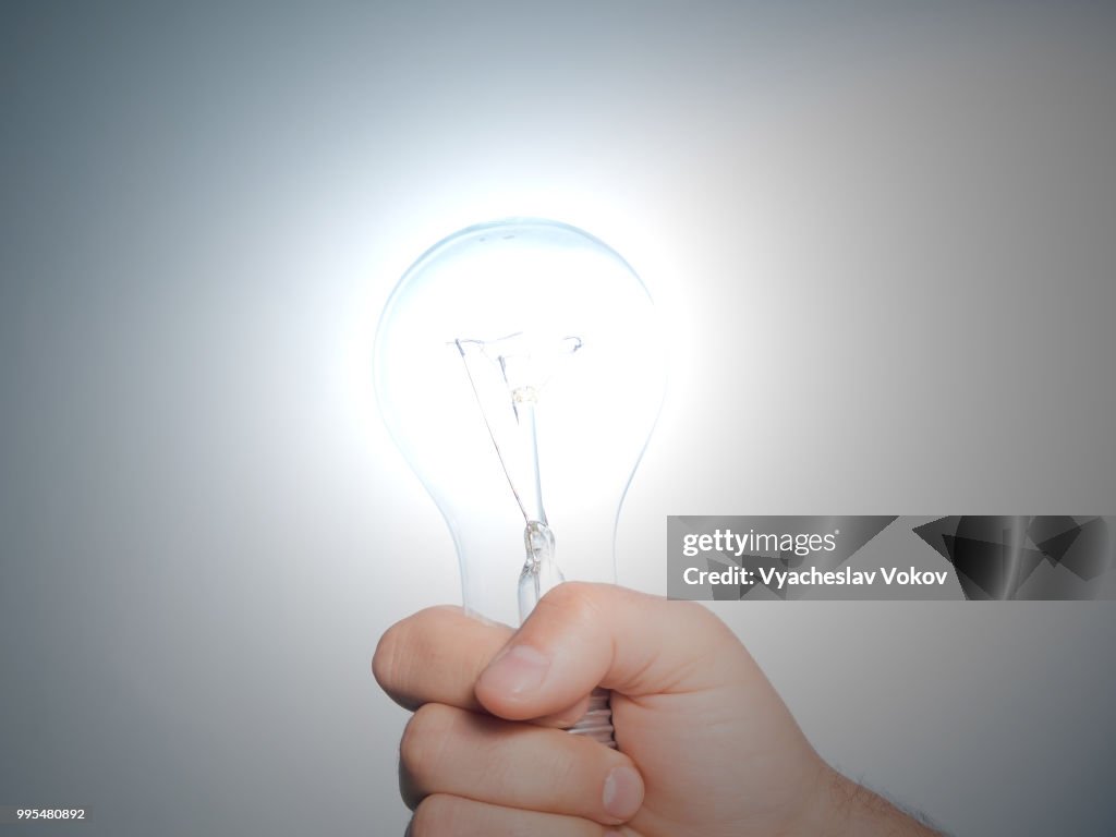 Hand holding an incandescent light bulb