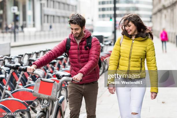 uk, london, young couple with rental bicycle from bike share stand - man riding bus stock pictures, royalty-free photos & images