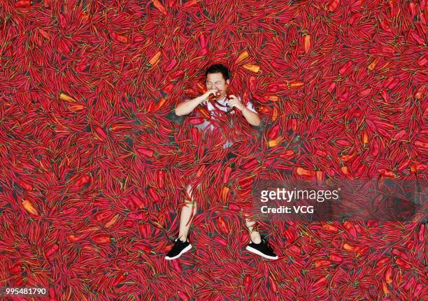Contestant lies in a chili covered pool eating Chillies during a chili eating contest on July 8, 2018 in Ningxiang, Hunan Province of China. Citizen...