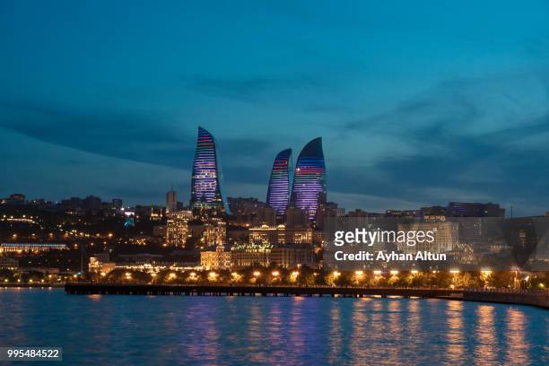the flame towers and caspian sea  from baku's boulevard park at dusk ,azerbaijan - baku foto e immagini stock
