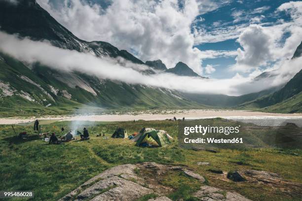 norway, lofoten, moskenesoy, young men camping at horseid beach - moskenesoya stock pictures, royalty-free photos & images