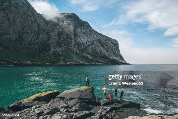 norway, lofoten, moskenesoy, young men fishing at horseid beach - moskenesoya stock pictures, royalty-free photos & images