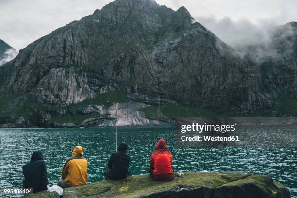 norway, lofoten, moskenesoy, young men fishing at horseid beach - moskenesoya stock pictures, royalty-free photos & images