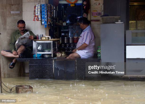 People deal with heavy rain and water logging near Z bridge Matunga Station on July 9, 2018 in Mumbai, India. Indias financial capital and its...