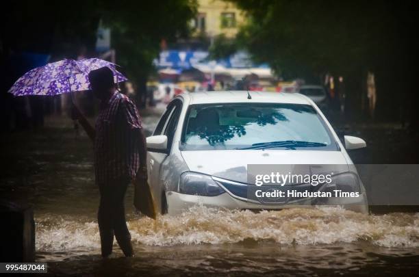 Vehicle zips through rain water near Dadar local railway station on July 9, 2018 in Mumbai, India. Indias financial capital and its surrounding...