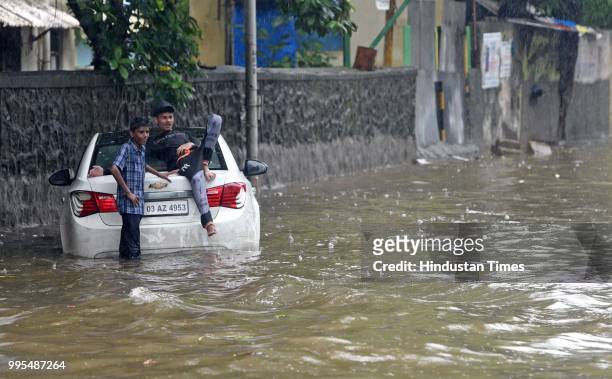 Vehicles and people wade through waterlogged street at SV Road,Khar on July 9, 2018 in Mumbai, India. Indias financial capital and its surrounding...