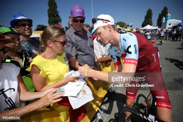 Ian Boswell of The United States and Team Katusha signs autographs for fans at the start during stage four of the 105th Tour de France 2018, a 195km...
