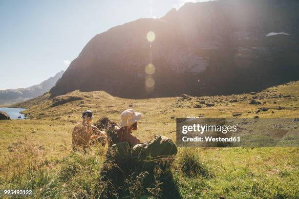 norway, lofoten, moskenesoy, young men resting at litljordtinden - moskenesoya stock pictures, royalty-free photos & images