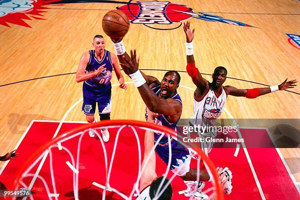 Karl Malone of the Utah Jazz shoots a layup against Hakeem Olajuwon of the Houston Rockets in Game Four of the Western Conference Finals during the...