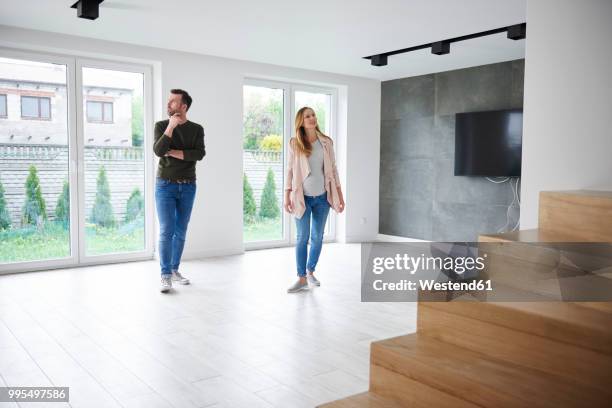 couple looking around in empty flat - looking around stock pictures, royalty-free photos & images