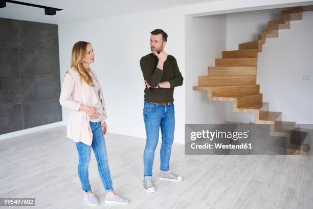 couple standing in empty flat - couple standing full length stock pictures, royalty-free photos & images