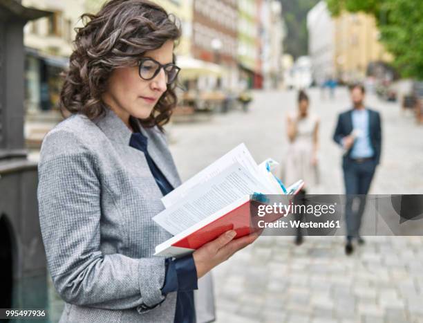 businesswoman reading book in the city - kufstein stock pictures, royalty-free photos & images