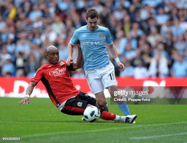 Adam Johnson of Manchester City is tackled by El Hadji Diouf of Blackburn Rovers during a Barclays Premier League match at the City of Manchester...