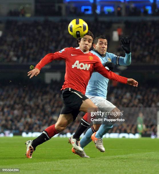 Rafael da Silva of Manchester United holds off Carlos Tevez of Manchester City during a Barclays Premier League match at the City of Manchester...