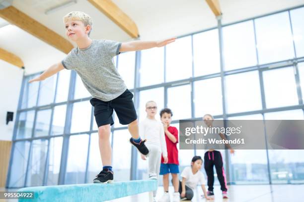 schoolboy balancing on balance beam in gym class - physical education 個照片及圖片檔