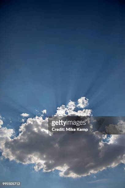Heavenly shafts of light as sunlight creates shadow from behind a cloud at Broadway in The Cotswolds, United Kingdom. Particles in the air are picked...