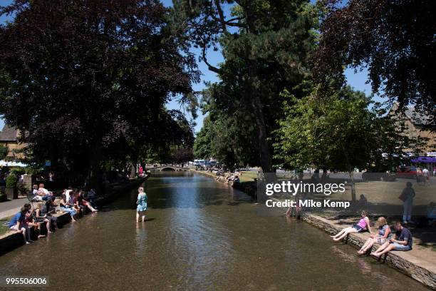 Bourton on the Water in The Cotswolds, United Kingdom. Bourton-on-the-Water is known for its picturesque High Street, flanked by long wide greens and...