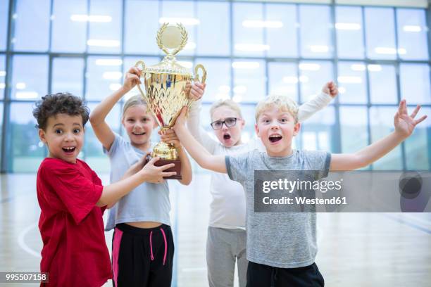 happy pupils holding trophy in gym - girls germany team presentation stock pictures, royalty-free photos & images