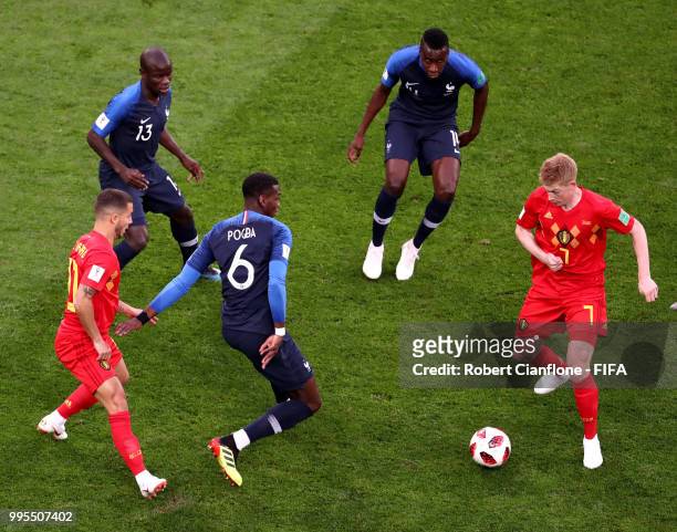 Kevin De Bruyne of Belgium is challenged by Paul Pogba, Ngolo Kante and Blaise Matuidi of France during the 2018 FIFA World Cup Russia Semi Final...