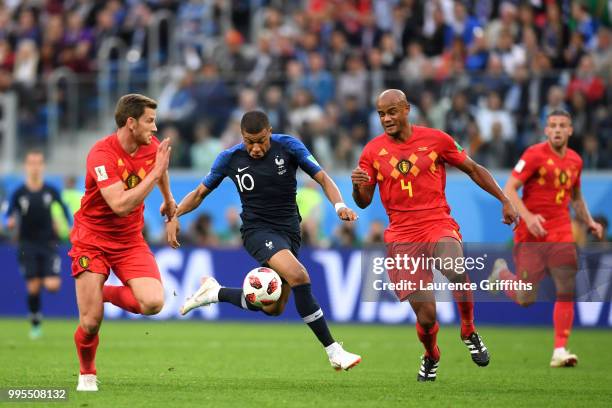 Kylian Mbappe of France is challenged by Jan Vertonghen and Vincent Kompany of Belgium during the 2018 FIFA World Cup Russia Semi Final match between...