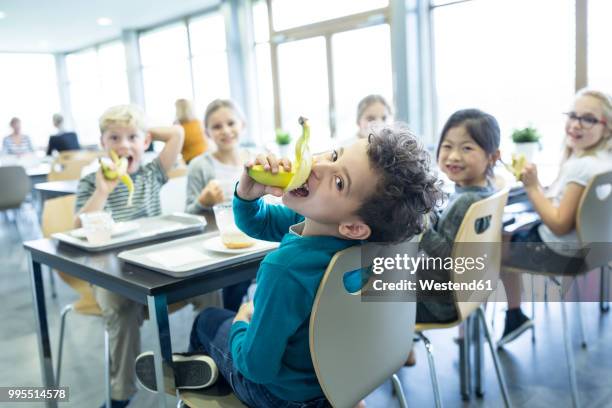 pupils having lunch in school canteen - kind schüler stock-fotos und bilder