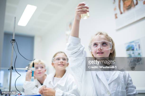 pupils in science class experimenting with liquid - school boy girl stock-fotos und bilder