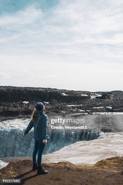 iceland, woman standing at dettifoss waterfall - dettifoss stockfoto's en -beelden