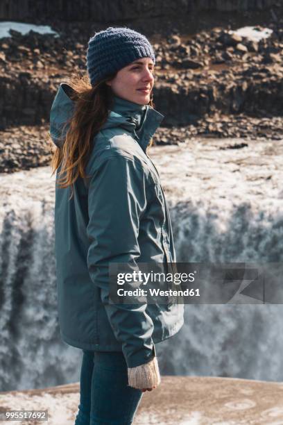 iceland, woman standing at dettifoss waterfall - dettifoss fotografías e imágenes de stock