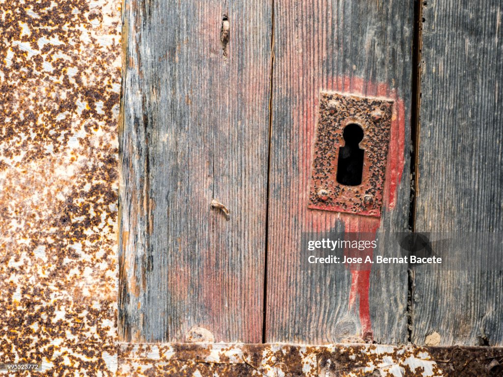 Door of ancient wood damaged in the time with nails and locks metallic rusted.