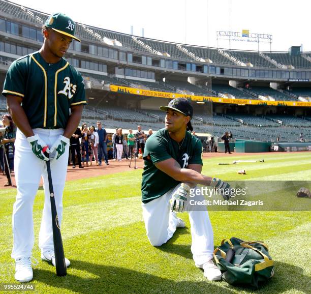 First round draft pick Kyler Murray of the Oakland Athletics stands on the field with Khris Davis after singing his contract at the Oakland Alameda...