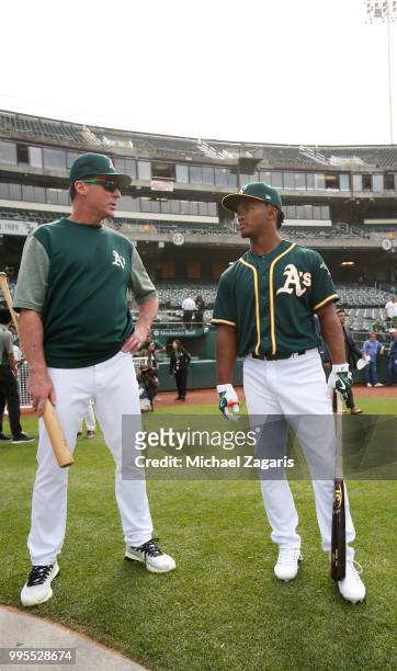 Manager Bob Melvin of the Oakland Athletics talks with first round draft pick Kyler Murray on the field after Murray signed his contract with the...