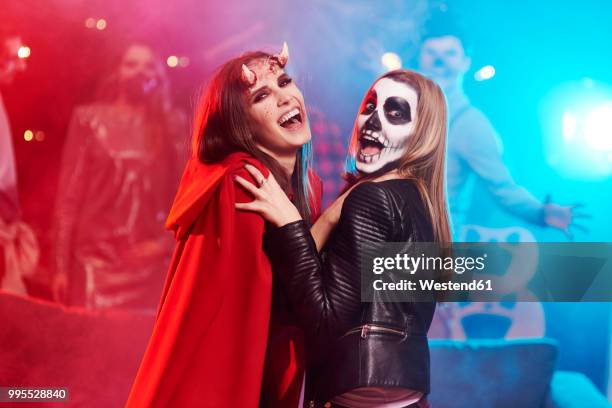 women in creepy costumes dancing at halloween party - costume foto e immagini stock