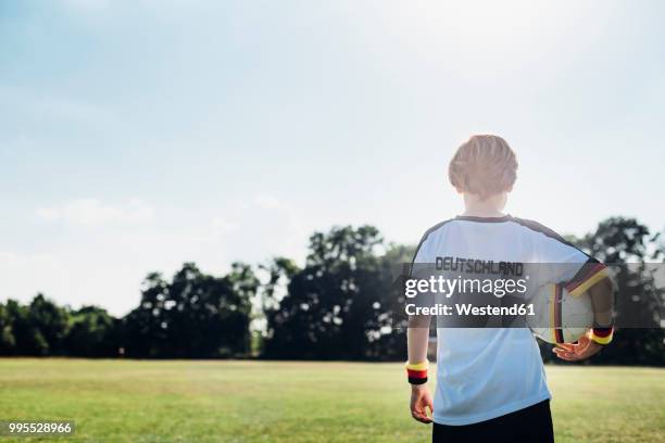 boy wearing football shirt with germany written on back - soccer back stock-fotos und bilder