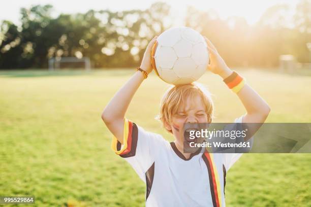 boy wearing german soccer shirt screaming for joy - meisterschaft stock-fotos und bilder