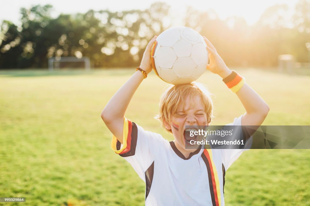 Boy wearing German soccer shirt screaming for joy