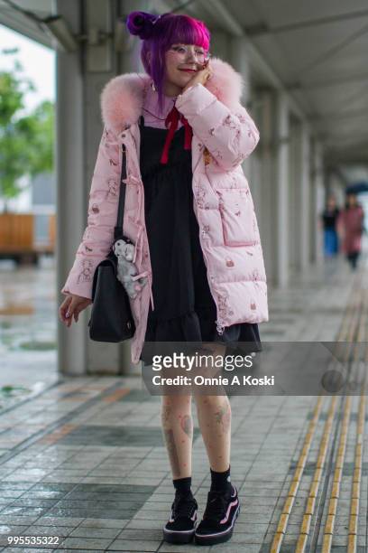Laura Anunnaki is wearing a coat by Bonbon 21, dress by Honey Cinamon, blouse by WeGo, shoes by Vans x Lazy Oaf at Tokyo Design Festa on May 18, 2018...