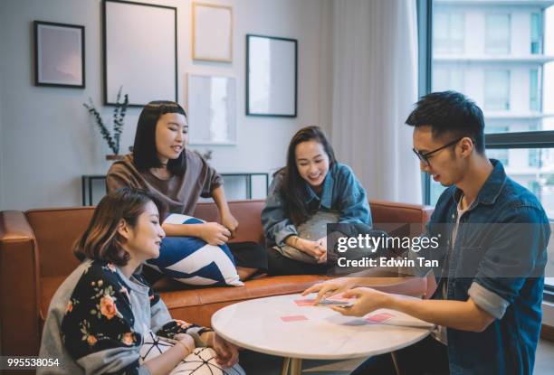 asian chinese friends playing poker cards game in living room - board games stock pictures, royalty-free photos & images