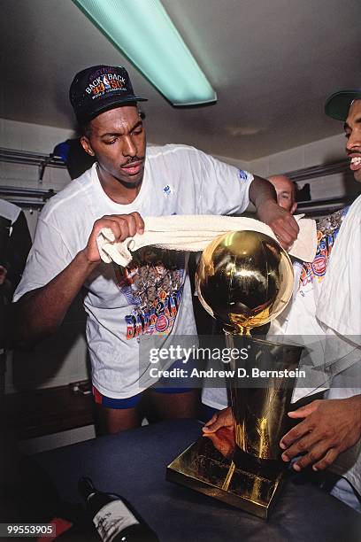 John Salley of the Detroit Pistons wipes the Larry O'Brien Trophy following Game Five of the 1990 NBA Finals on June 14, 1990 at the Memorial...
