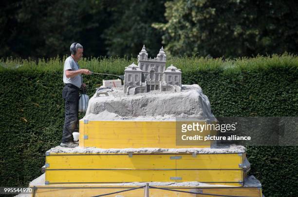 July 2018, Germany, Ludwigsburg: The Portuguese artist Pedro Mira working on his sand sculpture. The garden show Bluehendes Barock is exhibiting...